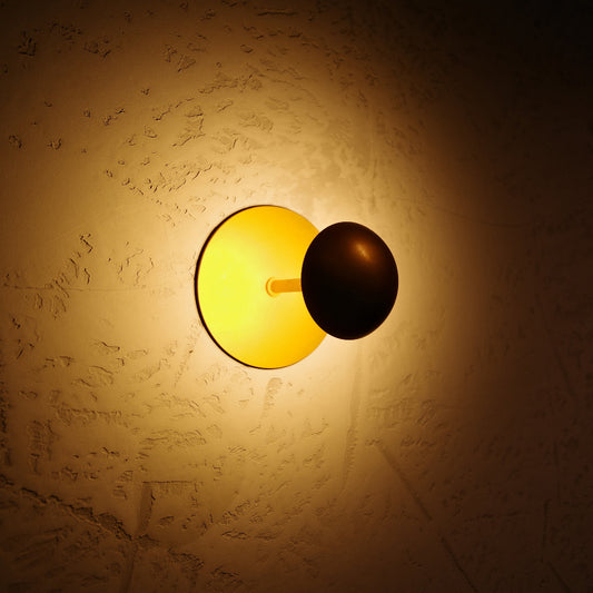 DINER S innoLED Wandleuchte rund schwarz, nicht dimmbar, gelbes LED-Licht an Putzwand