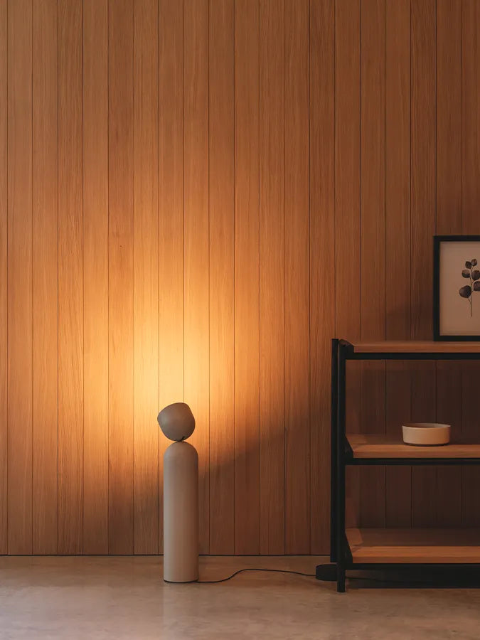 Stehleuchte Plusminus Solo von Vibia in Beige ausgerichtet auf eine mit Holz verkleidete Wand
