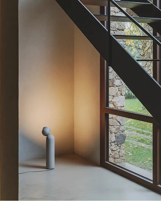 Stehleuchte Plusminus Solo von Vibia in Grün unter einer Treppe zur Ausleuchtung der Wand