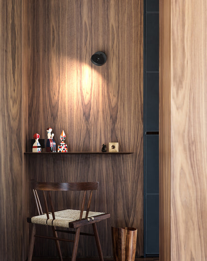 Rotaliana Wandleuchte String in Schwarz an einer Holzwand montiert und auf ein Regal gerichtet