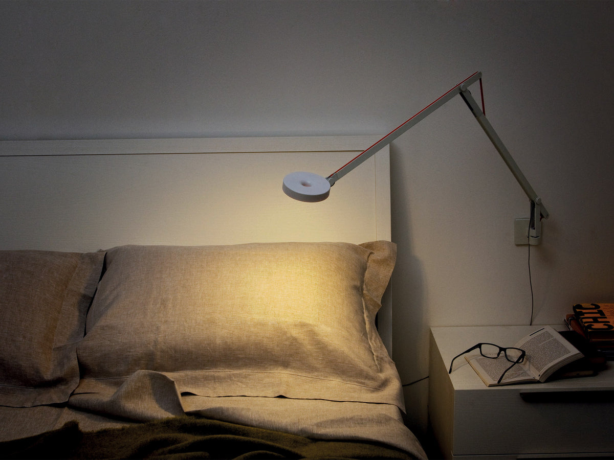 Wandleuchte String in Weiß von Rotaliana als Leseleuchte neben einem Bett an der Wand montiert
