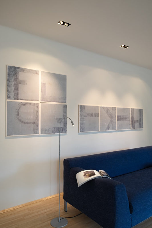 Zoom TisStehleuchte in silber neben einer Couch von DLS Lighting